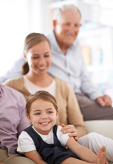 Were just one big happy family. Portrait of a smiling family sitting on the sofa at home.