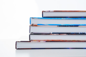 photobooks stacked on top of each other on a white table.