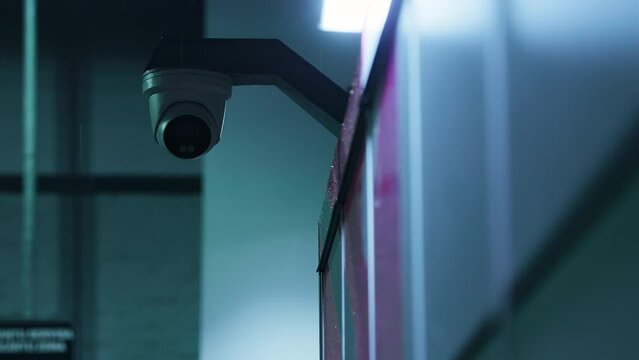 Rainy city night under surveillance by round-lensed CCTV