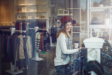 Im sure Ill find something. a young woman shopping at a clothing store.