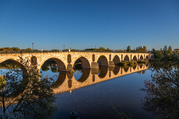 Fototapeta premium Beautiful panoramic view of Zamora roman bridge called Puente de Piedra, just before sunset, during Autumn season, on the Douro River, in Spain.