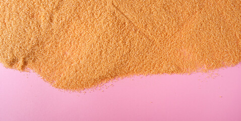 Fototapeta na wymiar A heap with Dry brown sugar on pink background, top view.