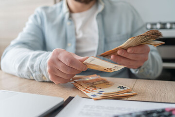 savings, finances, economy and home concept - close up of man with calculator counting money and...
