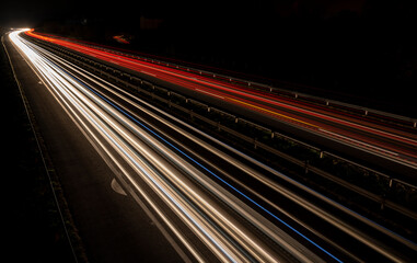 Cars light trails on a straight highway at sunset. Night traffic trails, Motion blur, Night city road with traffic headlight motion.	
