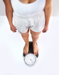 Ive lost some weight. High angle view of an unrecognizable woman standing on a scale to see her weight.