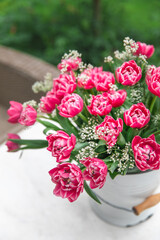 A bouquet of pink tulips in a white bucket