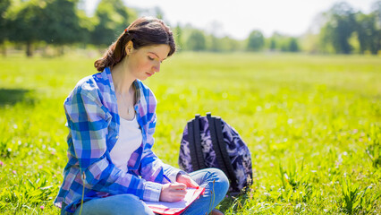 Student studying reading notes outside