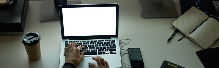 Work anytime. High angle view of hands of man sitting at the table in front of many computer...