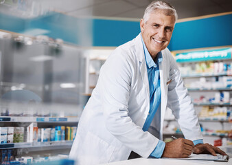 Im in the service of bettering lives. a male pharmacist writing on a clipboard in a drugstore.