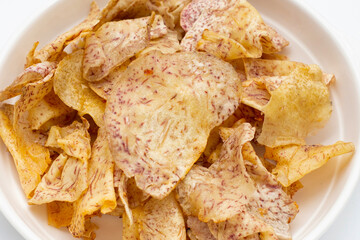Crispy taro chips on white background.