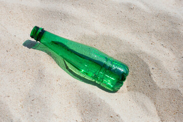 Green plastic bottle on the beach