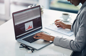 Shell get your finances looking good. an unrecognizable businesswoman using a laptop with graphs on it in a modern office.