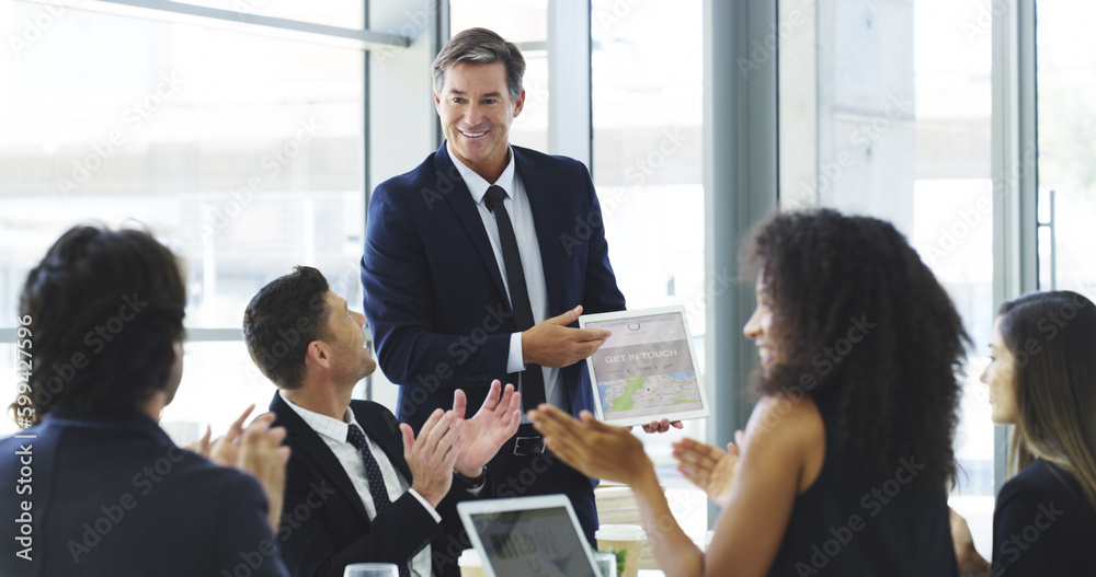 Poster applauding his efforts. a businessman using a digital tablet while giving a presentation to his coll
