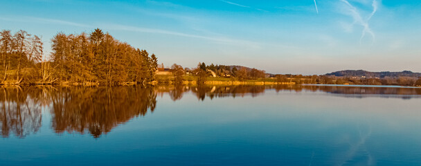 Winter landscape on a sunny day with reflections in a pond near Wiesenfelden, Bavarian forest, Straubing-Bogen, Bavaria, Germany