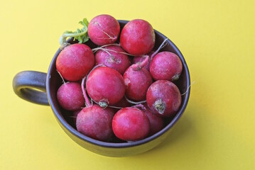 food of red fresh radish vegetables in brown cup on yellow table