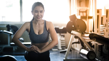 Fototapeta na wymiar Asian woman in the gym, warming up in the gym, healthy exercise Concept.