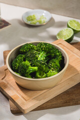 A bowl of blanched cooked broccoli trees