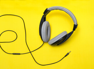 Audífonos negros-grises con cable sobre fondo amarillo 