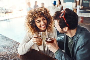 So, when can I get your number. a happy young man and woman having beers at a bar.