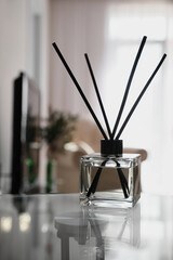 Aromatic reed air freshener on table indoors, space for text