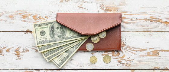 Wallet with money on light wooden background, top view