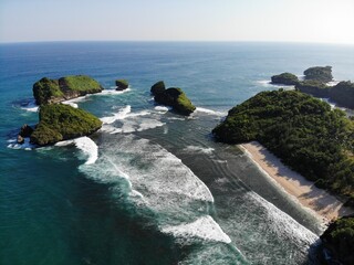 The beautiful landscape and scenery of ocean during sunset and sunny day. The long coastal beach with sand and rocky beach. Location in Pacitan, East Java Province, Indonesia.