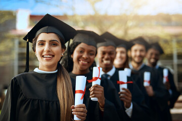 Becoming the people we dreamt of being. Portrait of a group of young students holding their...