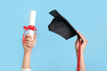 Woman with graduation hat and diploma on blue background - obrazy, fototapety, plakaty