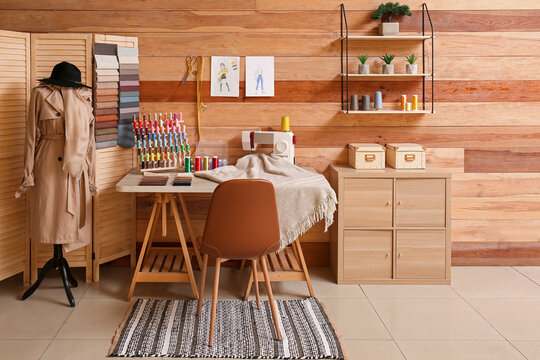 Interior of stylish atelier with tailor's workplace, mannequin and shelf