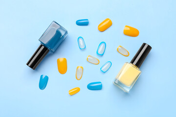 Press-on nails with polishes on blue background
