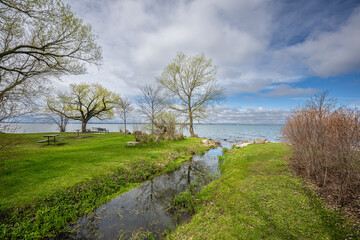 Fototapeta na wymiar Discover the breathtaking beauty of Keswick's Claredon Beach Park with these stunning 45MP photos. The collection showcases the picturesque views of Lake Simcoe, verdant green grass.