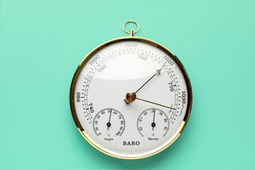 Aneroid barometer on turquoise background