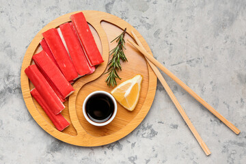 Plate with tasty crab sticks and sauce on grunge background © Pixel-Shot