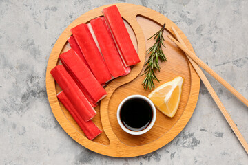 Plate with tasty crab sticks and sauce on grunge background © Pixel-Shot