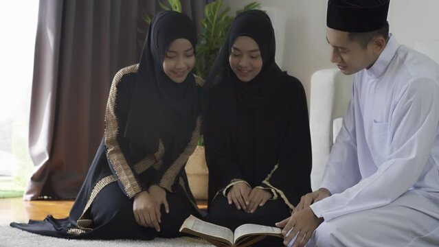 Asian Muslim family reciting surah al-Fatiha passage of the Qur'an, daily prayer at home, a single act of sujud called a sajdah or prostration. Quran holy book is a public item of all Muslim