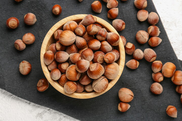Bowl with shelled hazelnuts on table