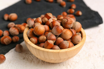 Bowl with shelled hazelnuts on table