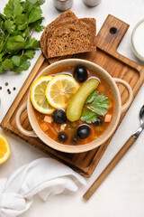 Pot with tasty Hodgepodge soup on light background