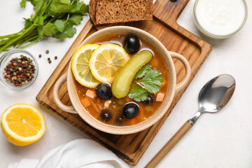 Pot with tasty Hodgepodge soup on light background