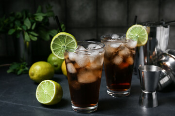Glasses of cold Cuba Libre cocktail on dark background