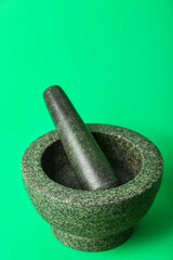 Mortar and pestle on green background