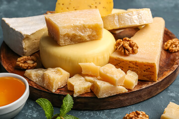 Plate with different types of cheese on blue background