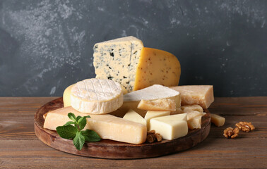 Plate with different types of tasty cheese on table