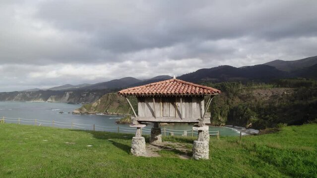 Backwards dolly shot from a horreo by the sea, typical granary from Asturias the north of the Iberian Peninsula, traditional farm building