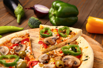 Board with vegetable pizza and ingredients on wooden background