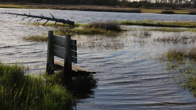 Bench covered up with water from high tide, coastal flooding