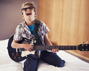 Youre never too young to learn a Slayer riff. A little boy playing an electric guitar in his...