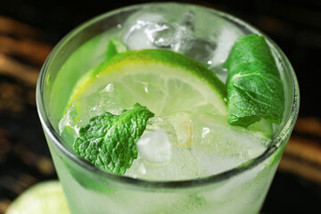 Glass of tasty mojito on table, closeup
