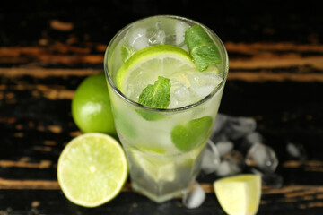 Glass of tasty mojito on dark wooden background