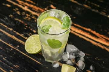 Glass of tasty mojito on dark wooden background